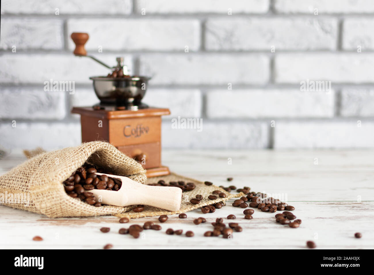 Manuelle vintage Kaffeemühle und Kaffeebohnen in einem sackleinen Tasche auf einem Holztisch. Kopieren Sie Platz. Stockfoto