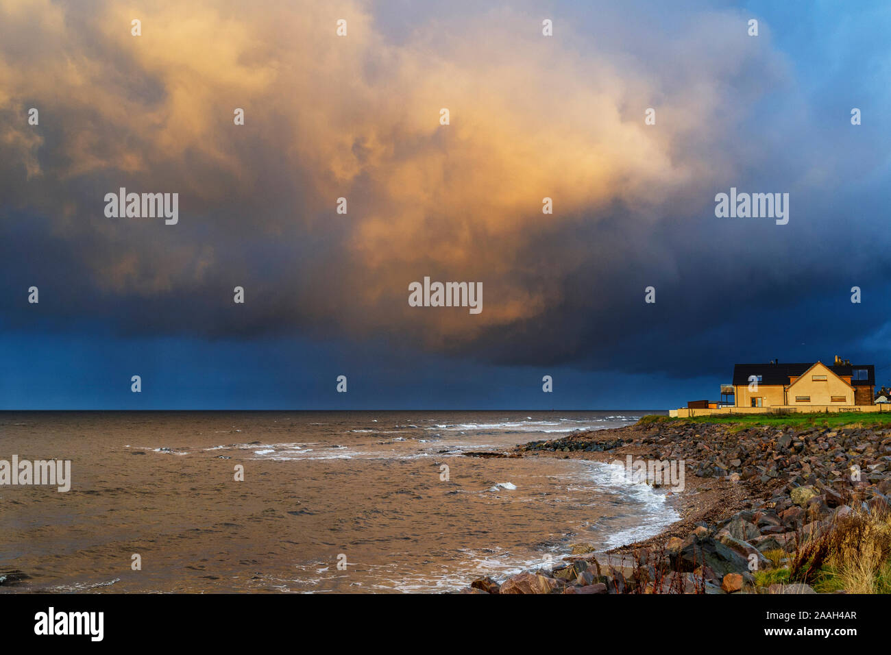 Sonnenuntergang und ein schwerer Regen Wolken über der Küste EIN HAUS UND DAS MEER Stockfoto