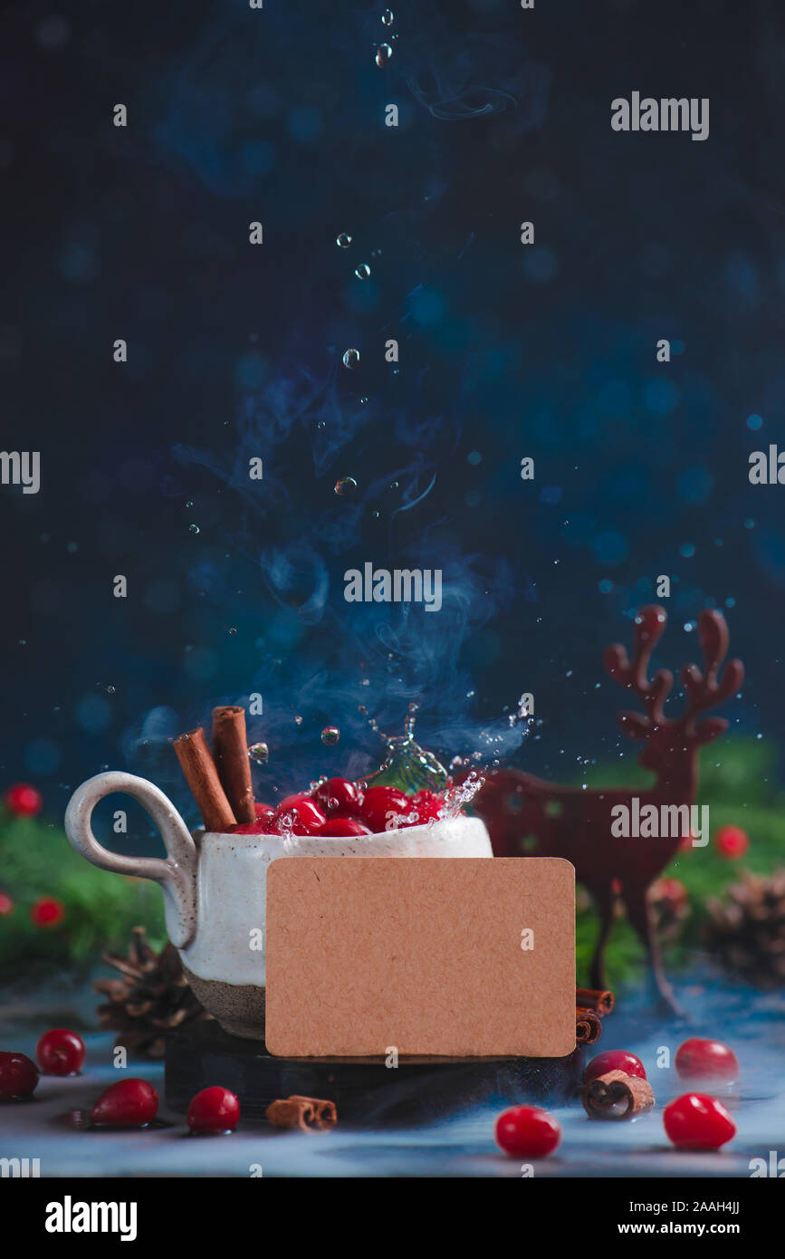 Cranberry Winter trinken mit Wassertropfen, schwarze Karte, ein Dampfbad und eine Hölzerne dekorative Hirsche. Stockfoto