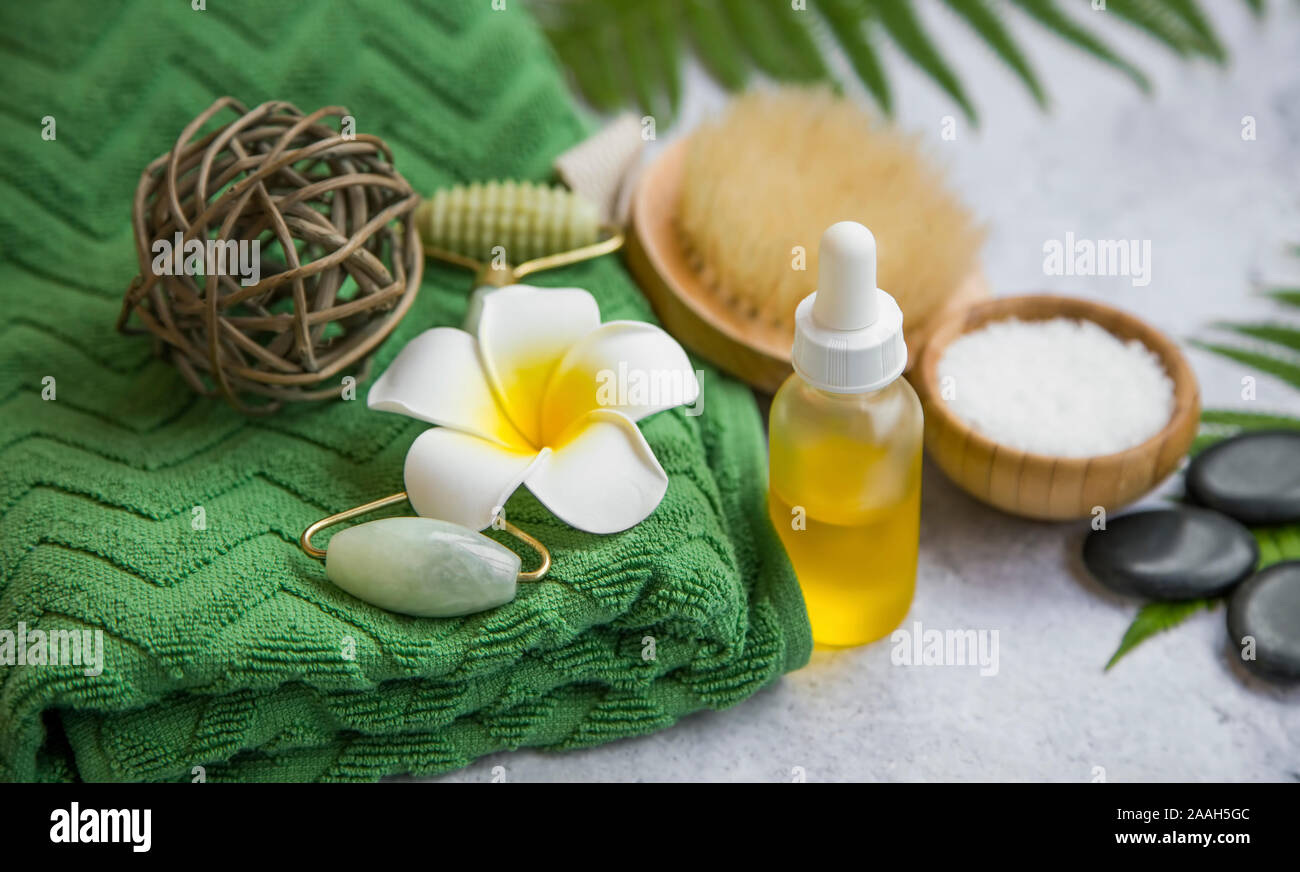 Spa Noch leben Einstellung mit Frangipani Blume, Öl Flasche, Badesalz, Massage Steine, Handtuch und grüne Blätter, Wellness und Spa Einstellung Stockfoto
