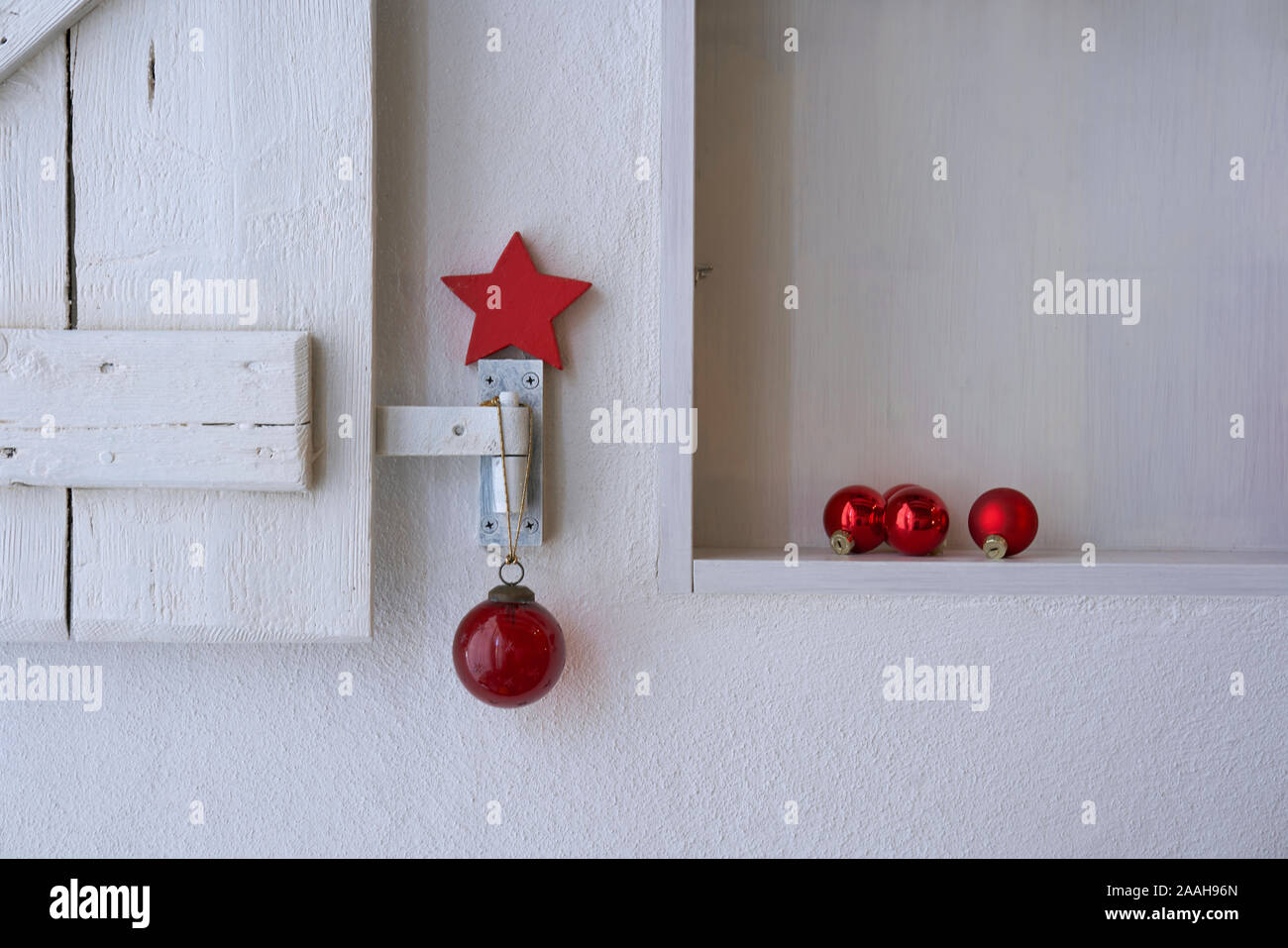 Nahaufnahme von einem weißen Regal mit einem weißen schäbig Holz- Shutter schön mit roten Weihnachten Dekoration, skandinavischen Stil Stockfoto