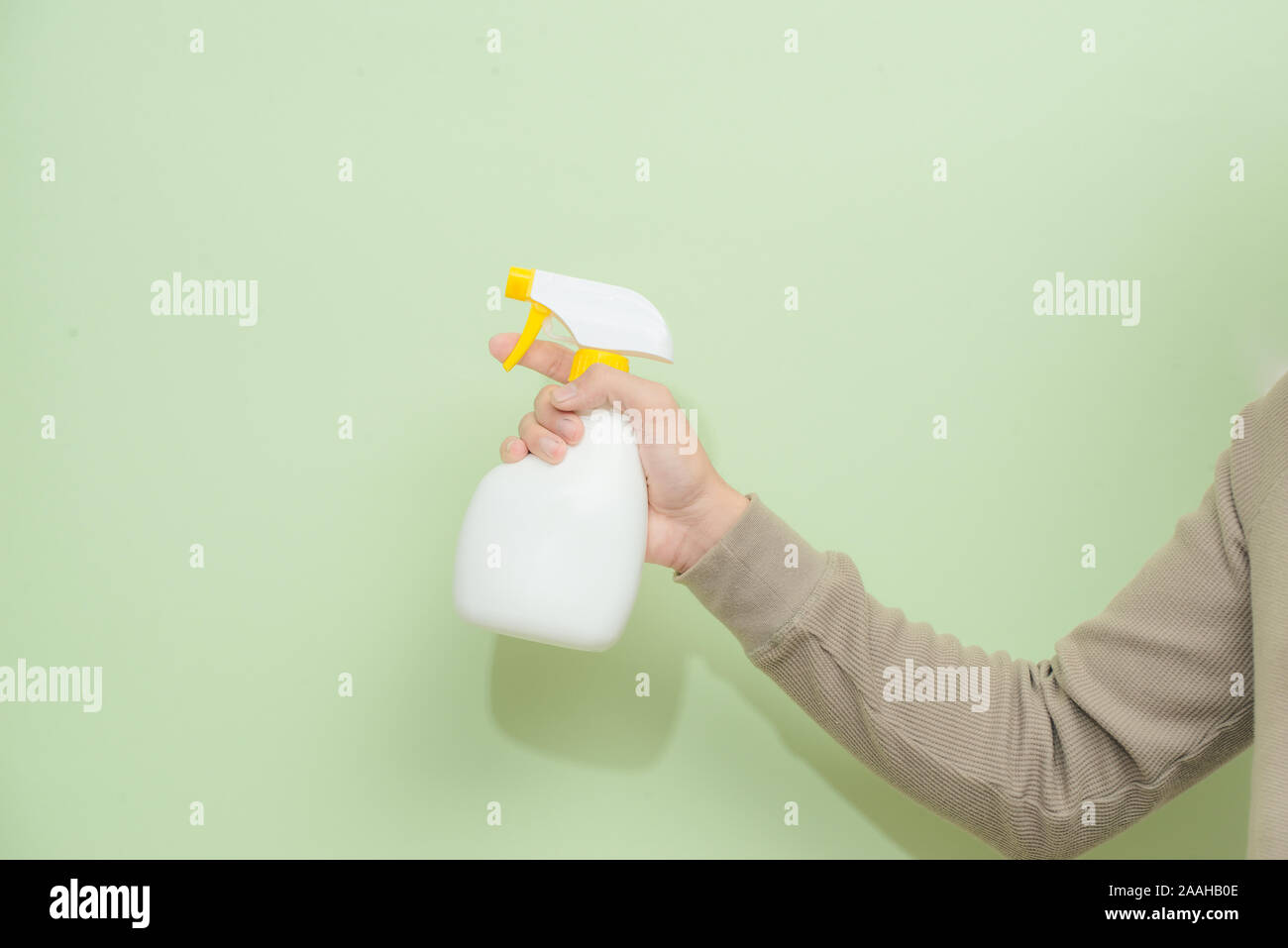 Männliche hand mit Feldspritze auf grünem Hintergrund isoliert Stockfoto