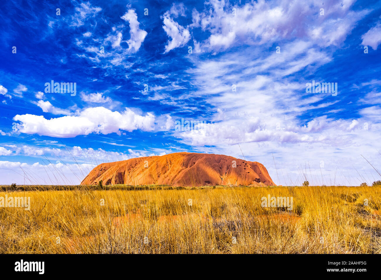 Uluru, auch Ayers Rock genannt, mit atemberaubenden Wolkenbildung an einem sonnigen Tag. Northern Territory, Australien Stockfoto