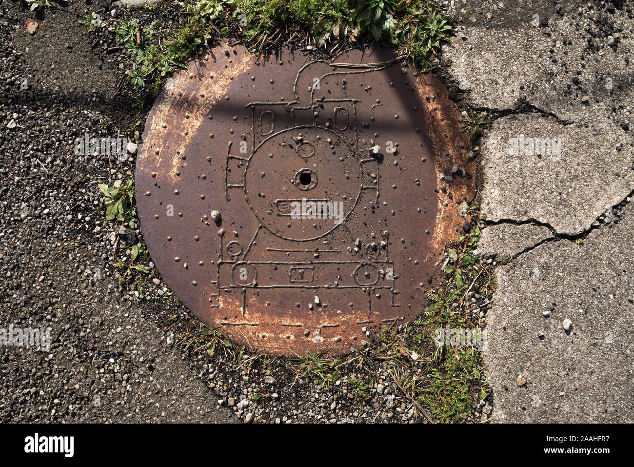 Kanaldeckel mit Motiv Lokomotive, railway Park, Augsburg, Schwaben, Bayern, Deutschland Stockfoto