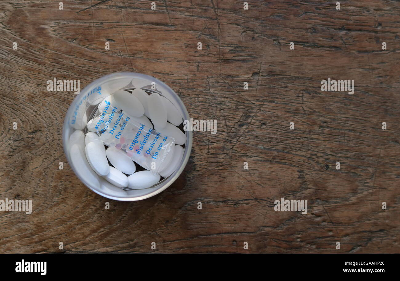 Closeup durchlässig Trockenmittel gel Beutel in der Flasche für den Schutz der Droge Pillen aus Feuchtigkeit, Worte auf dem Beutel zu lesen Trockenmittel Gel, nicht Essen Stockfoto