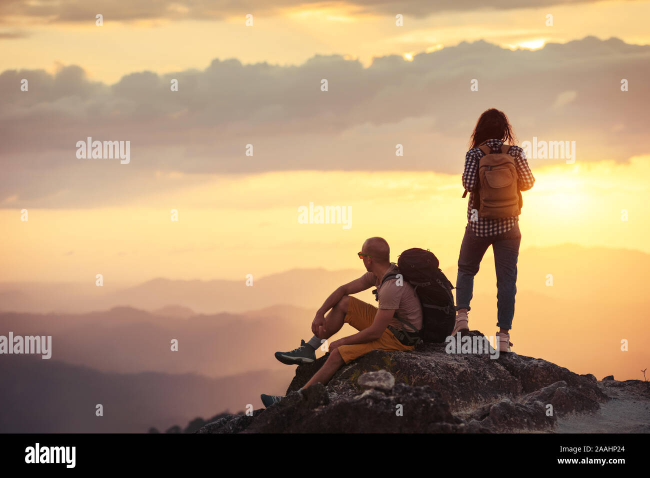 Paar Wanderer mit Rucksäcke sind in Ruhe am Berg bei Sonnenuntergang Zeit Stockfoto