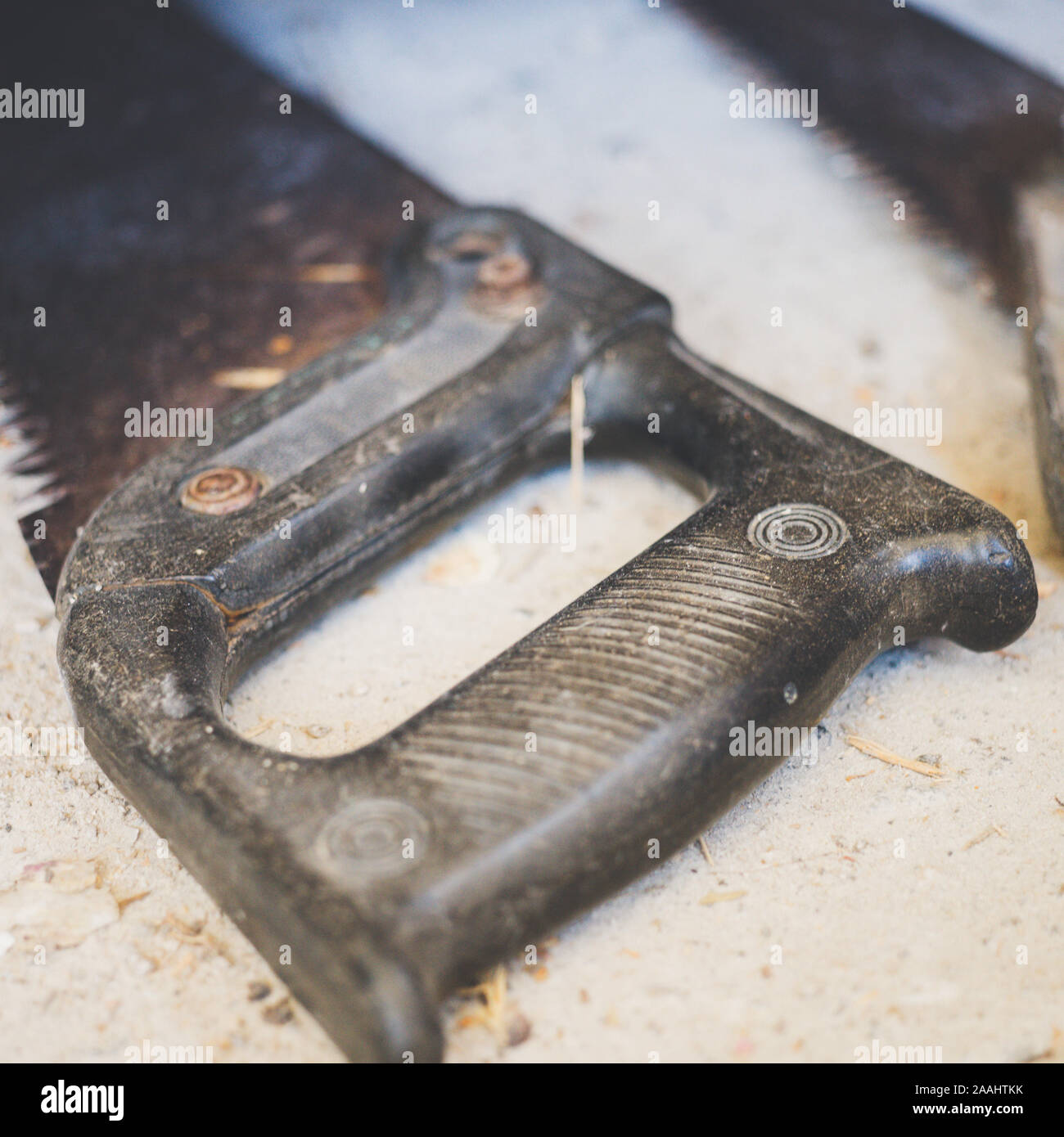 Kunststoff schwarz, alte Säge auf einem Steinboden, close-up. Stockfoto
