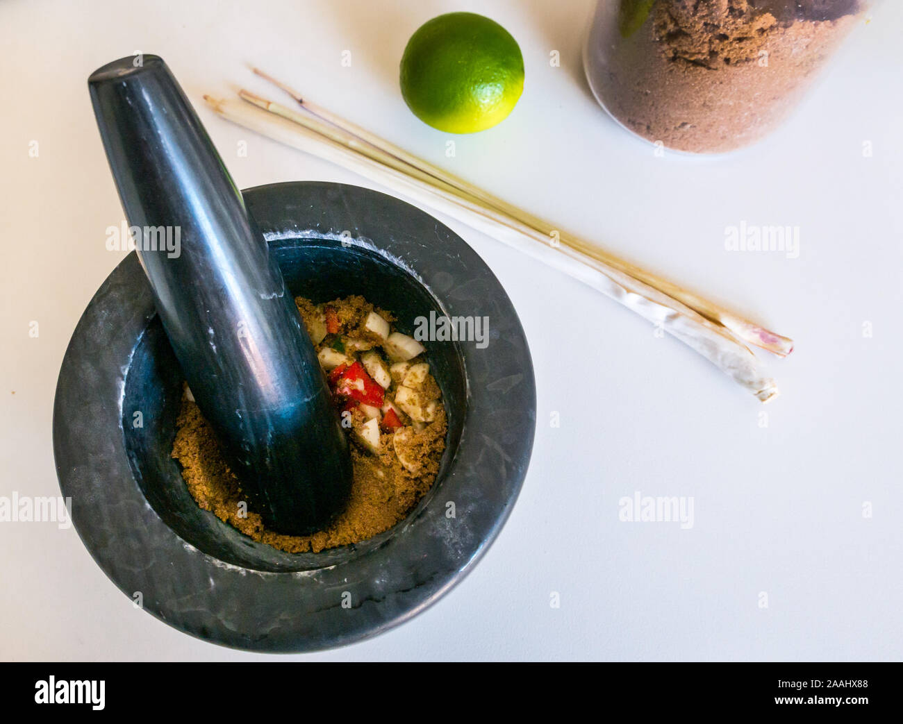 Schwarz Mörser bereit zu Zutaten für Nước chấm Schleifen, Vietnamesisch Soße, zubereitet mit Zitronengras, Kalk und brauner Zucker Stockfoto