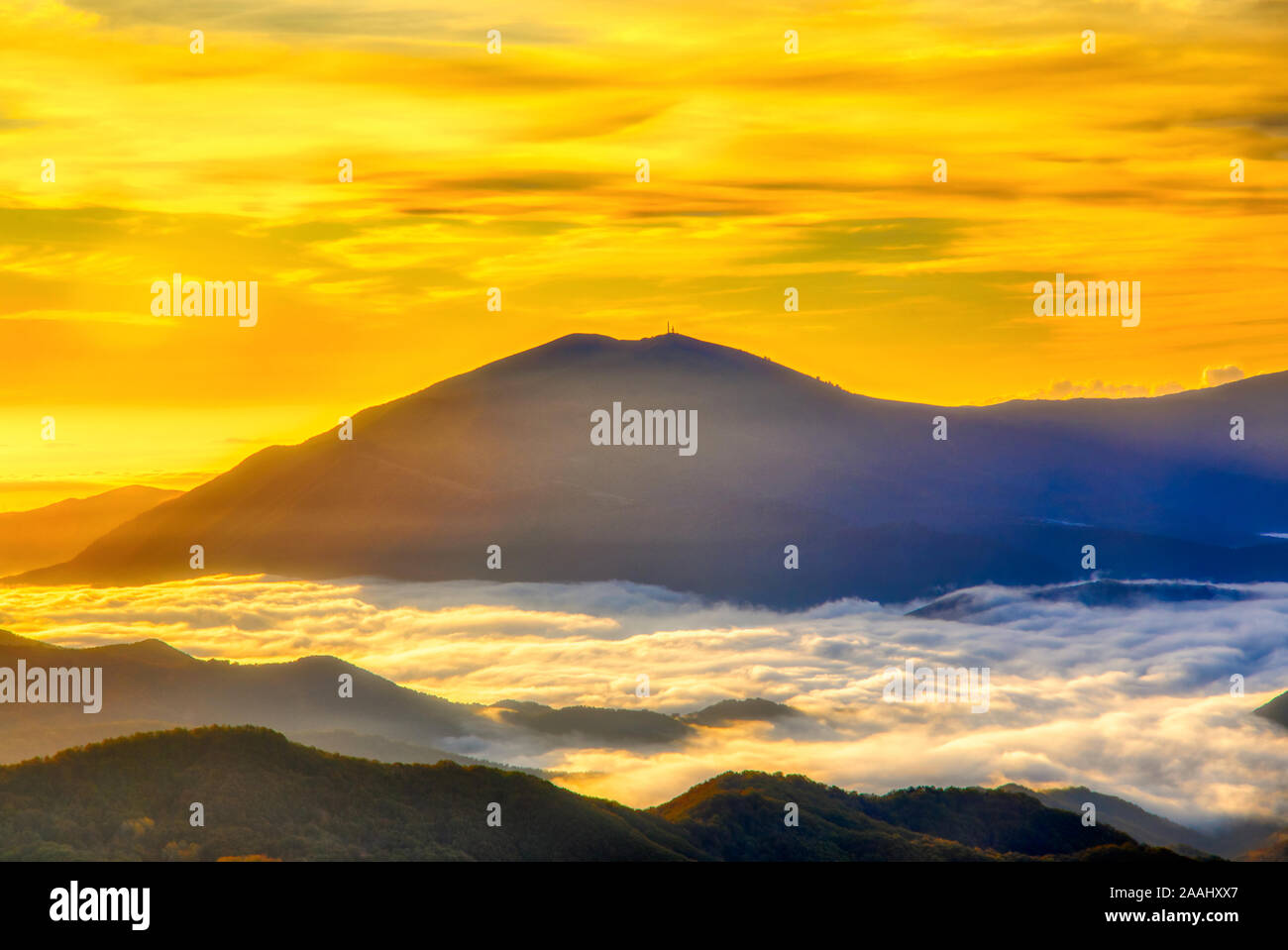 Erstaunlich Sonnenaufgang über neblige Landschaft. Malerischer Blick auf Nebligen Morgen Sky mit der aufgehenden Sonne über dem nebligen Wald. Rhodopen. Xanthi Thrakien, Griechenland Stockfoto