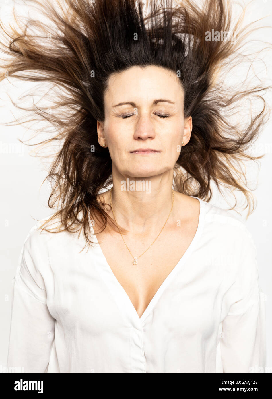 Frau mit fliegenden Haare schließen die Augen, weißer Hintergrund Stockfoto