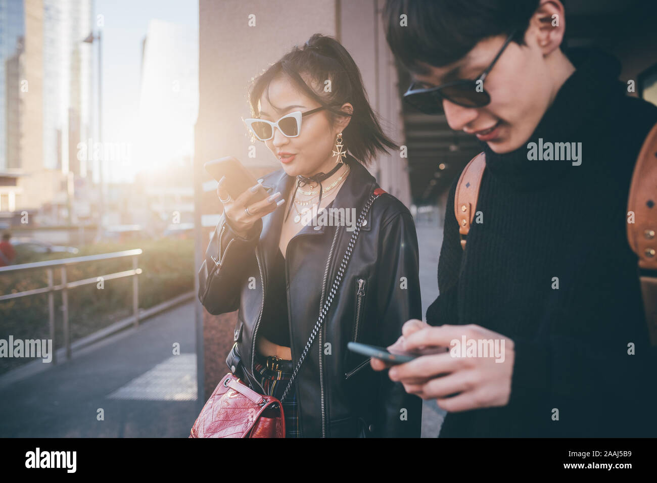 Junges Paar mit Handy beim Gehen auf die Straße, Mailand, Italien Stockfoto