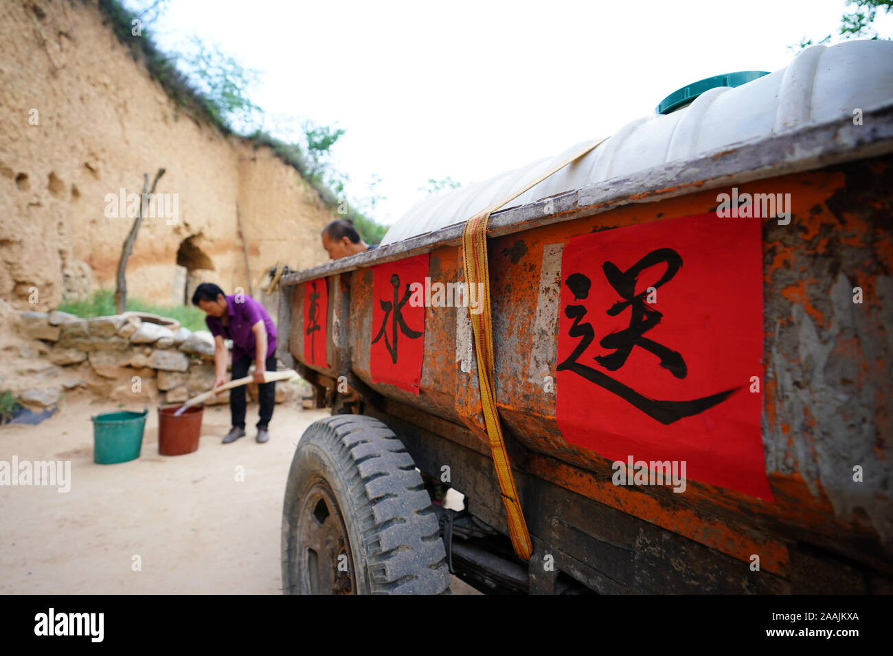 (191122) - YICHENG COUNTY, November 22, 2019 (Xinhua) - ein Dorf offizielle hilft, Wasser zu einem Dorfbewohner in Nanling Dorf Yicheng County verteilen, im Norden der chinesischen Provinz Shanxi, 3. Juli 2019. Da der Schalter gezogen wurde, das Wasser spritzte aus 403 Meter in Down Under. Nanling's Village sehr zuerst tief - Wasser gut ging, in einem frühen Wintermorgen. In der Vergangenheit, das Dorf, über die Schluchten des Zhongtiao Berge im Norden Chinas verbreiten, hatte allein auf Mud-pits stützte seine wertvollen Trinkwasser für Jahrhunderte zu speichern. Durch die Angst vor der Dürre heimgesucht, die Generationen hatte davon geträumt, Stockfoto