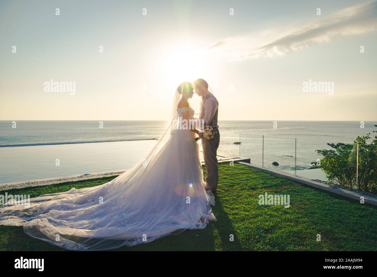Paar Liebe umarmen mit Gesicht gemütlich mit Sonnenuntergang in der Zeremonie Hochzeit in der Nähe von Meer zu Gesicht Stockfoto