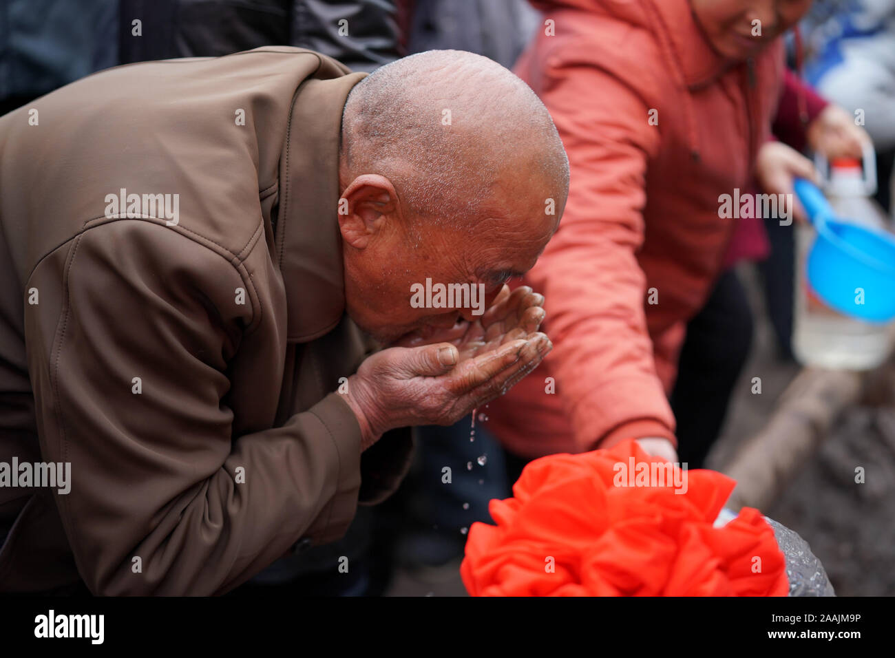 (191122) - YICHENG COUNTY, November 22, 2019 (Xinhua) - ein dorfbewohner Getränke Wasser, Schaufelte mit Händen nach einem tiefen Wasser gut begonnen, das Pumpen von Grundwasser in Nanling Dorf Yicheng County, Nov. 20, 2019. Da der Schalter gezogen wurde, das Wasser spritzte aus 403 Meter in Down Under. Nanling's Village sehr zuerst tief - Wasser gut ging, in einem frühen Wintermorgen. In der Vergangenheit, das Dorf, über die Schluchten des Zhongtiao Berge im Norden Chinas verbreiten, hatte allein auf Mud-pits stützte seine wertvollen Trinkwasser für Jahrhunderte zu speichern. Durch die Angst vor der Dürre, gen Haunted Stockfoto