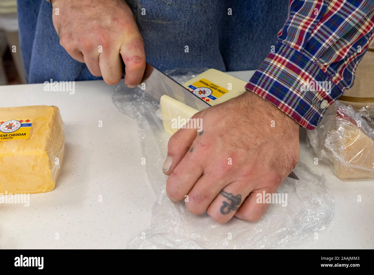 Auroraville, Wisconsin - Fred Buhrow schneidet Scheiben extra scharfe Cheddar für Besucher Union Star Käse zu probieren. Union Star ist eine von nur einem handfu Stockfoto