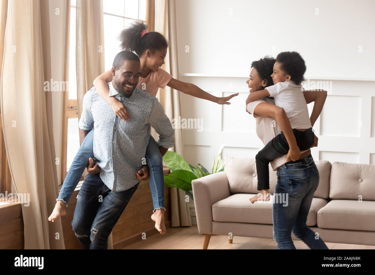 Afrikanische Eltern spielen mit Kindern sie tragen auf der Rückseite Stockfoto