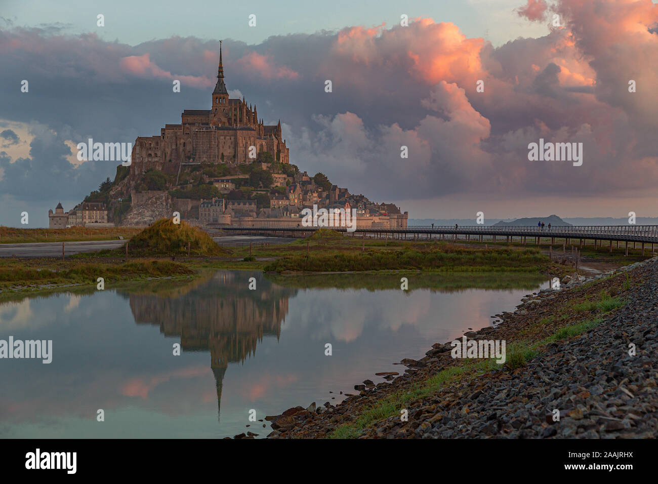 Der Normandie, Frankreich. Le Mont Saint Michel, mit einem großen roten Wolke in das Meer bei Sonnenaufgang reflektiert. Stockfoto