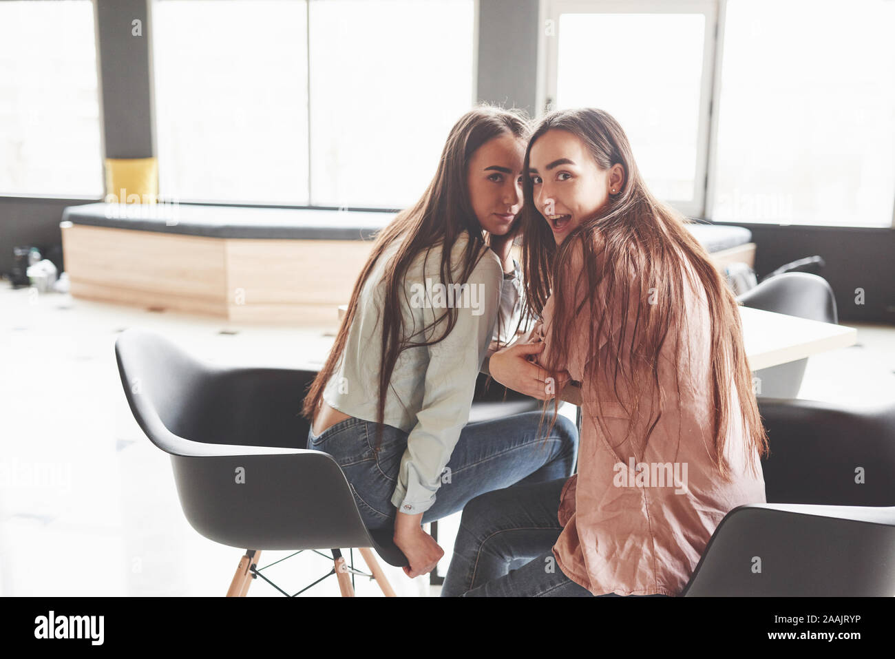 Zwei schöne twin Mädchen verbringen. Schwestern in ein Cafe und gemeinsam Spaß haben und Flüstern Stockfoto