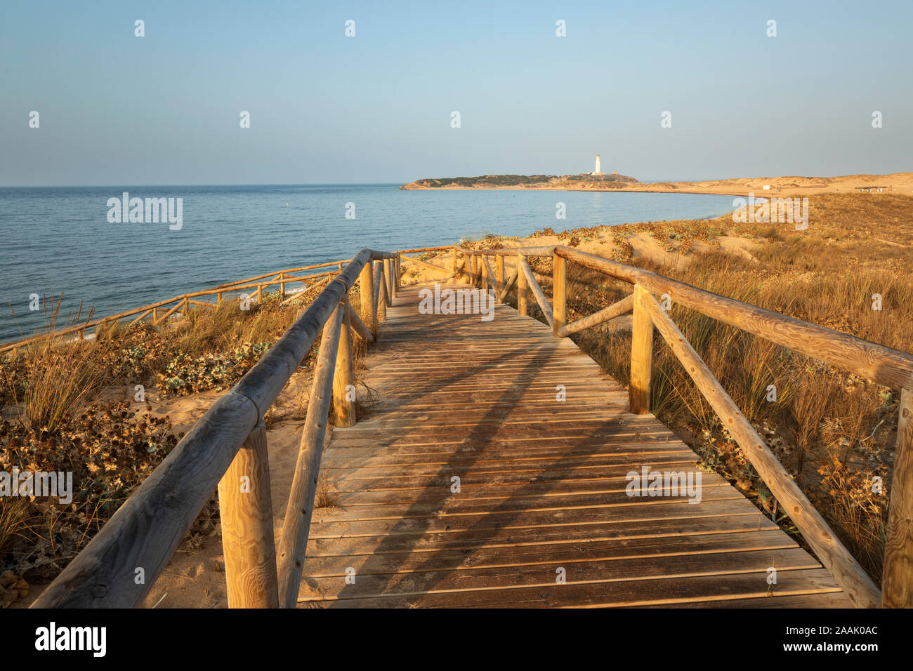Holzsteg hinunter zum Strand am Kap Trafalgar mit dem Leuchtturm hinter, Los Caños de Meca, Costa de la Luz, Provinz Cadiz, Andalusien, Spanien Stockfoto
