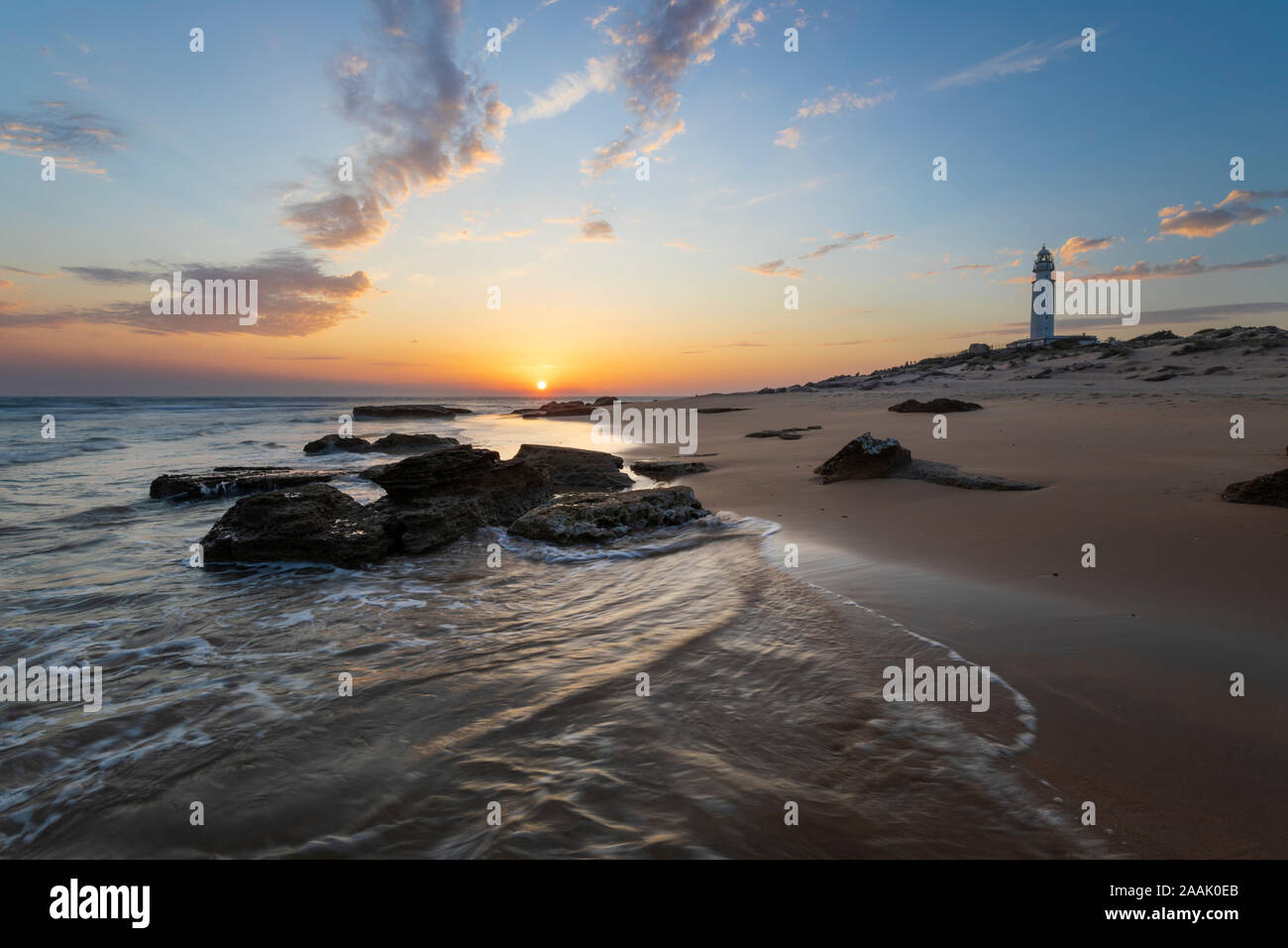 Kap Trafalgar Leuchtturm bei Sonnenuntergang mit Wellen am Strand brechen, Los Caños de Meca, Costa de la Luz, Provinz Cadiz, Andalusien, Spanien, Europa Stockfoto