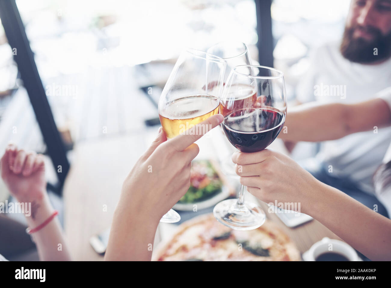 Freunde erhielt gemeinsam durch Tisch mit leckerem Essen mit Gläser Rotwein einen besonderen Anlass zu feiern. Stockfoto