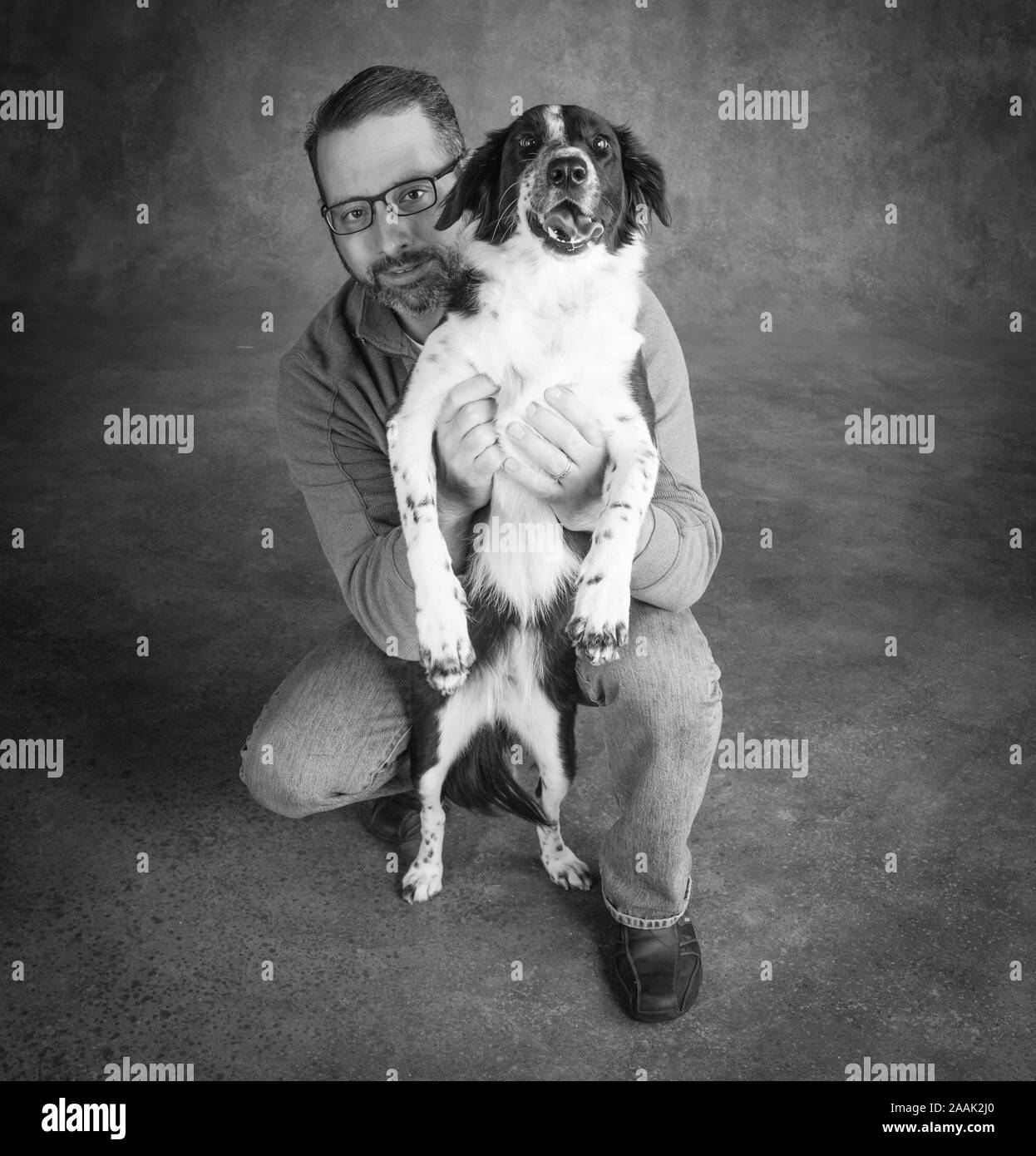 Studio Portrait von Mann mit Border Collie Mix Stockfoto