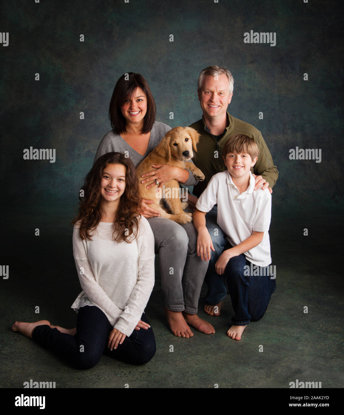 Porträt der Familie mit Golden Retriever Welpen Stockfoto