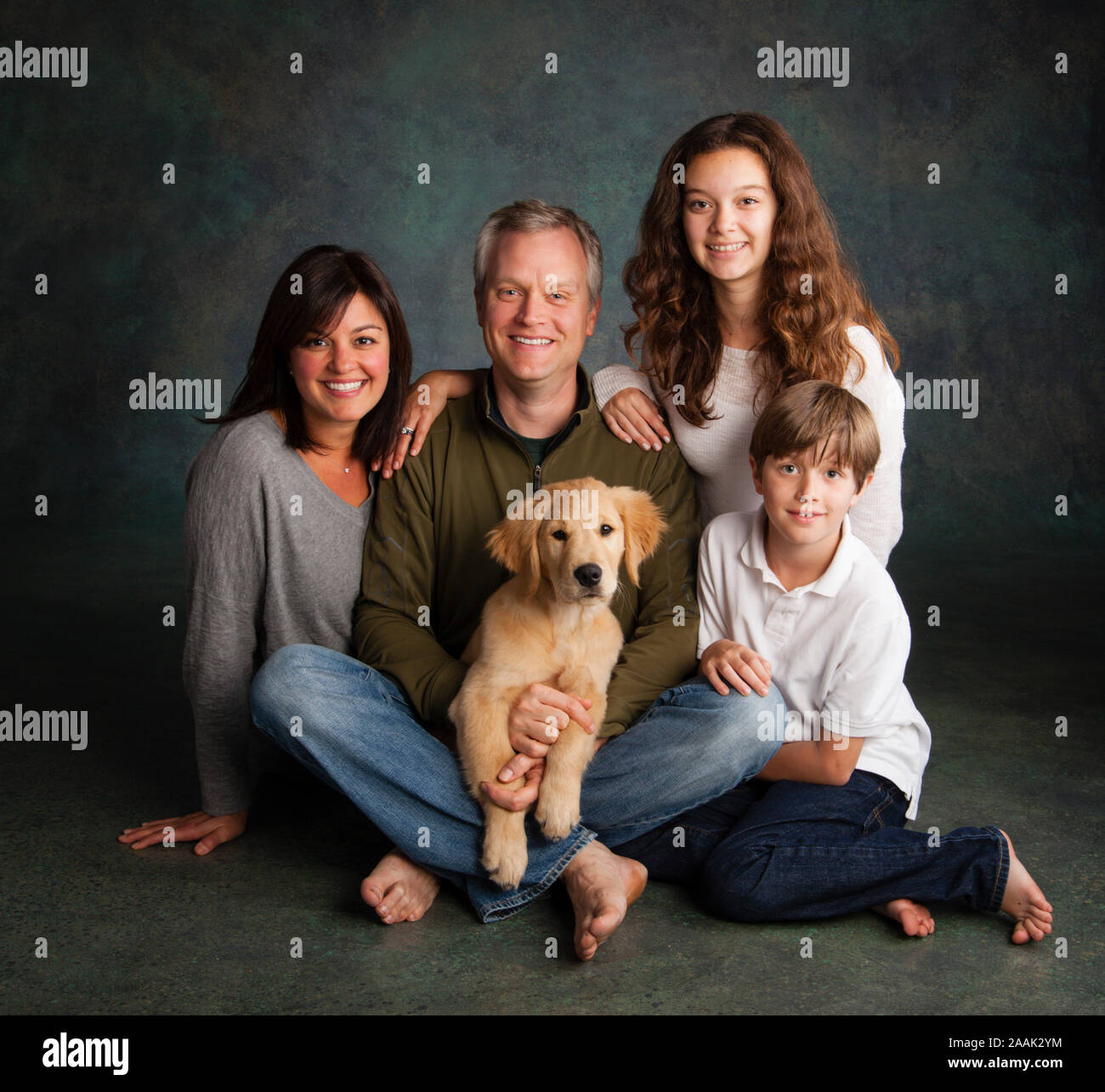 Porträt der Familie mit Golden Retriever Welpen Stockfoto