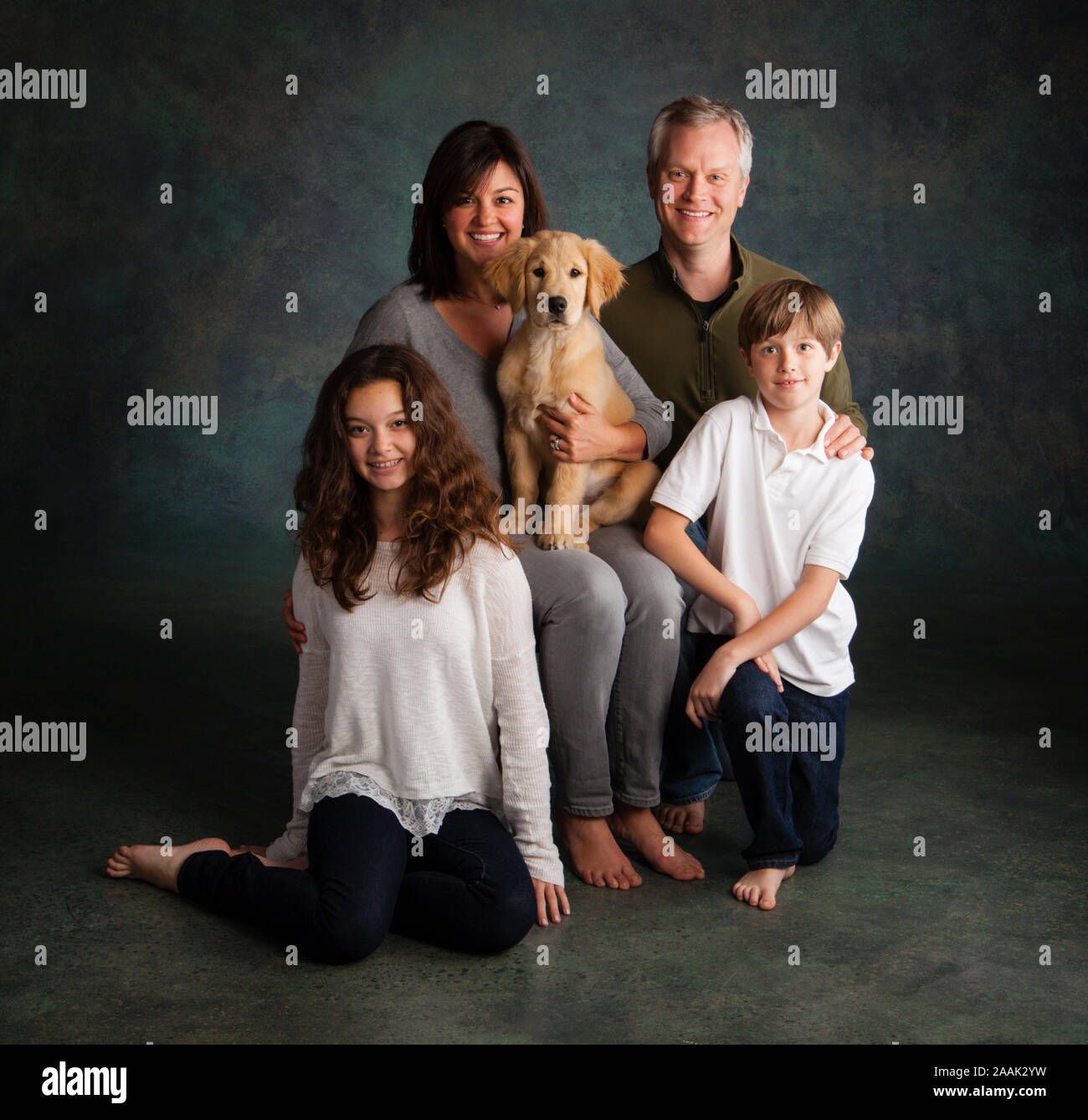 Porträt der Familie mit Golden Retriever Welpen Stockfoto