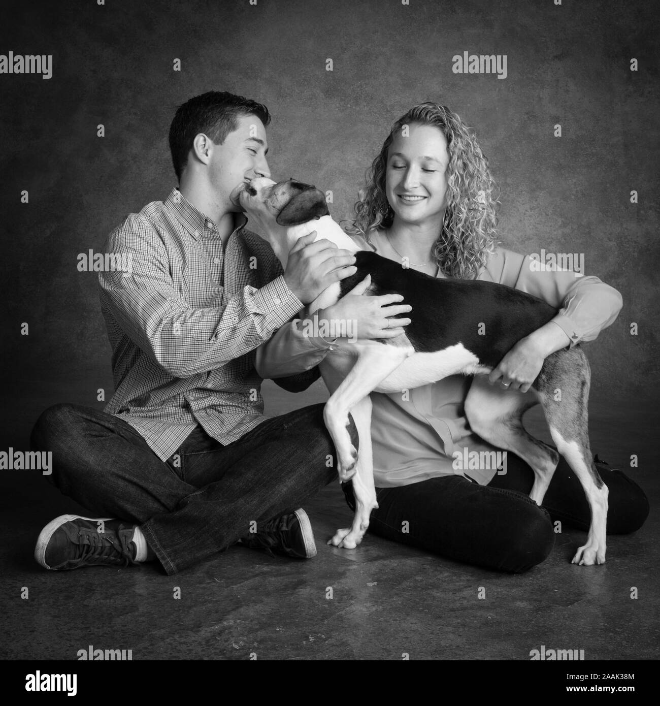 Studio geschossen von Paar mit gemischten Rasse Hund Stockfoto