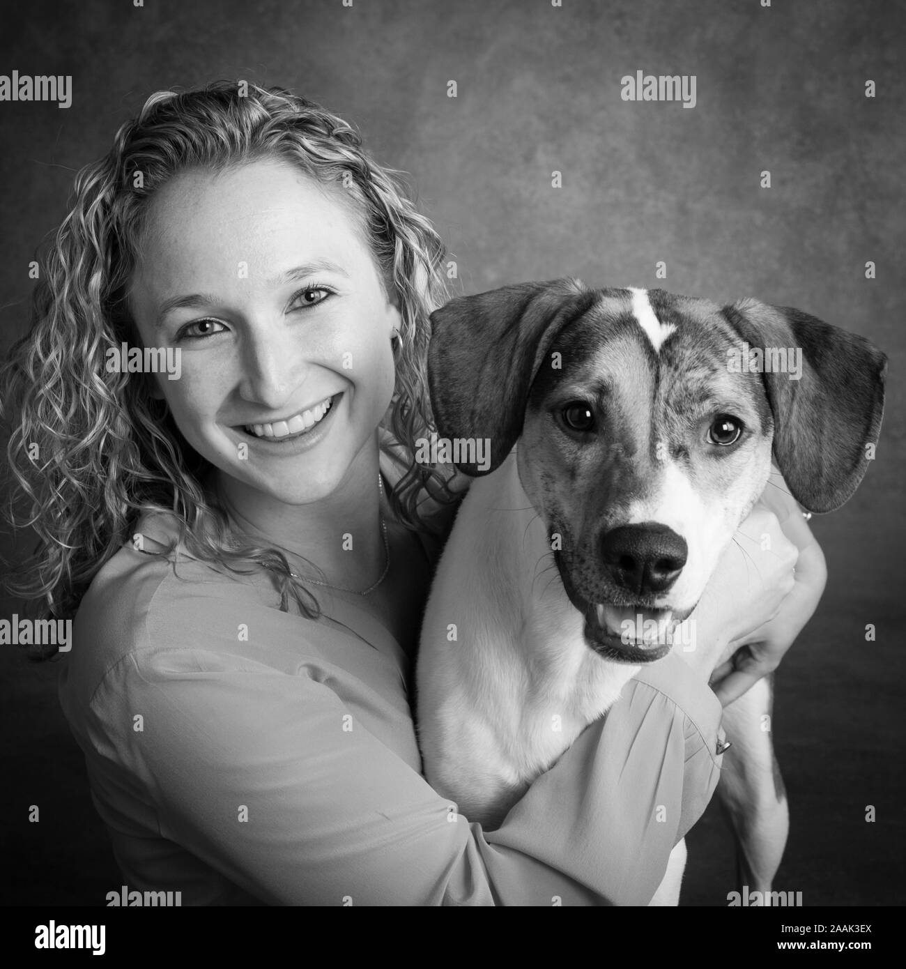 Studio Portrait von lächelnde Frau mit gemischten Rasse Hund Stockfoto