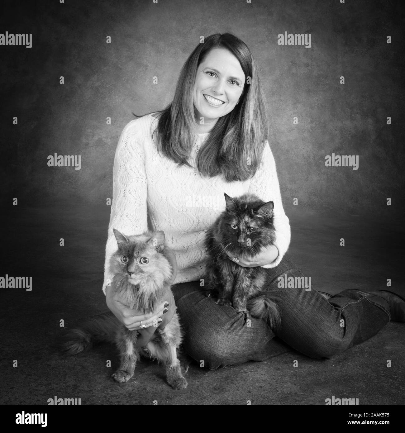 Studio Portrait von lächelnde Frau mit zwei langhaarige Katzen Stockfoto