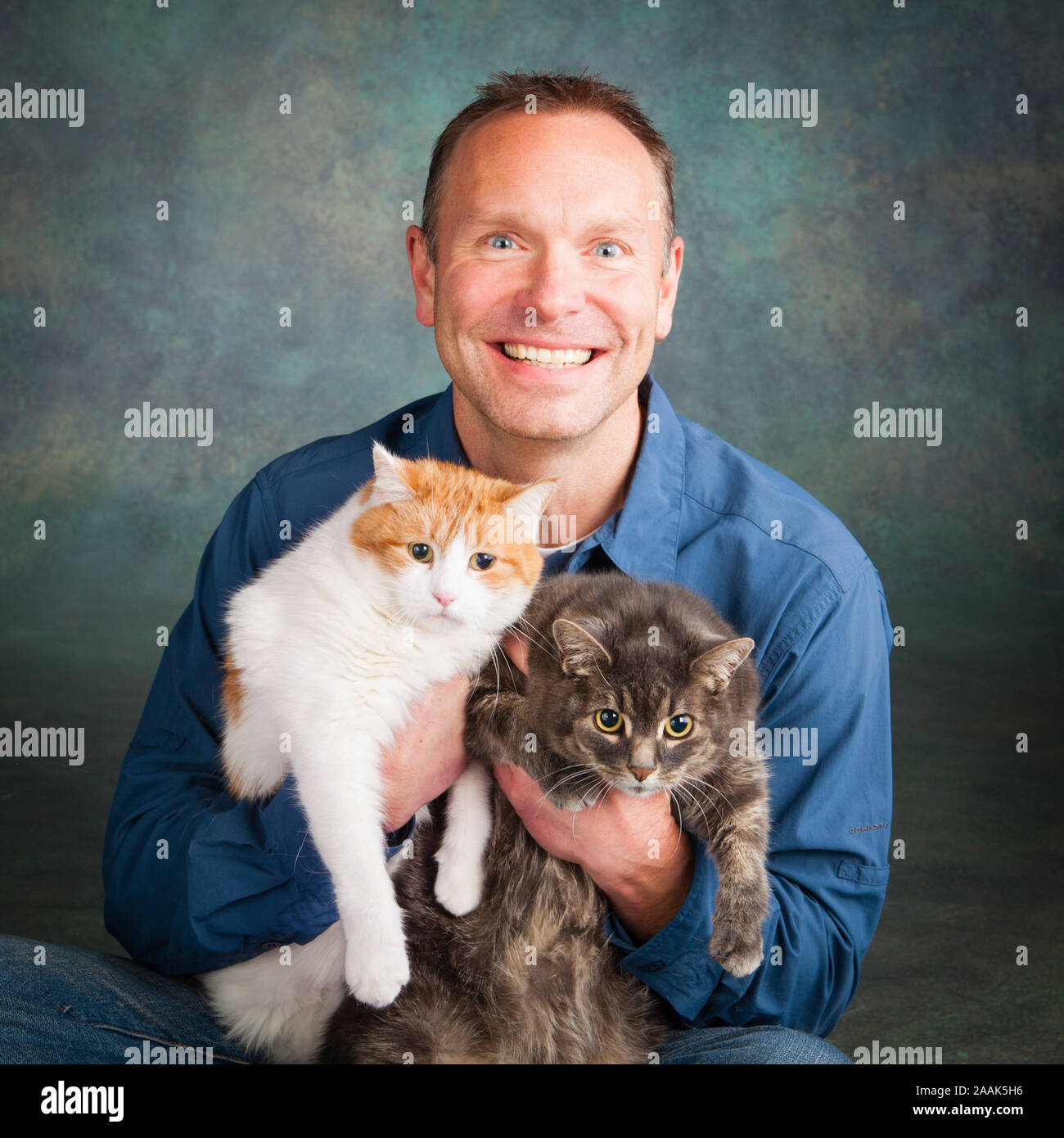 Studio Portrait von lächelnden Mann mit zwei Katzen. Stockfoto