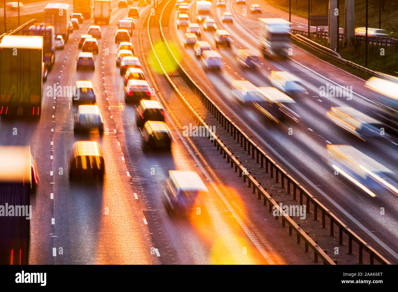 Feierabendverkehr auf der M60-Autobahn in der Nähe von Manchester bei Sonnenuntergang, UK. Verbrauch von einer Gallone Benzin emittiert rund 10,2 Kg C02. Stockfoto