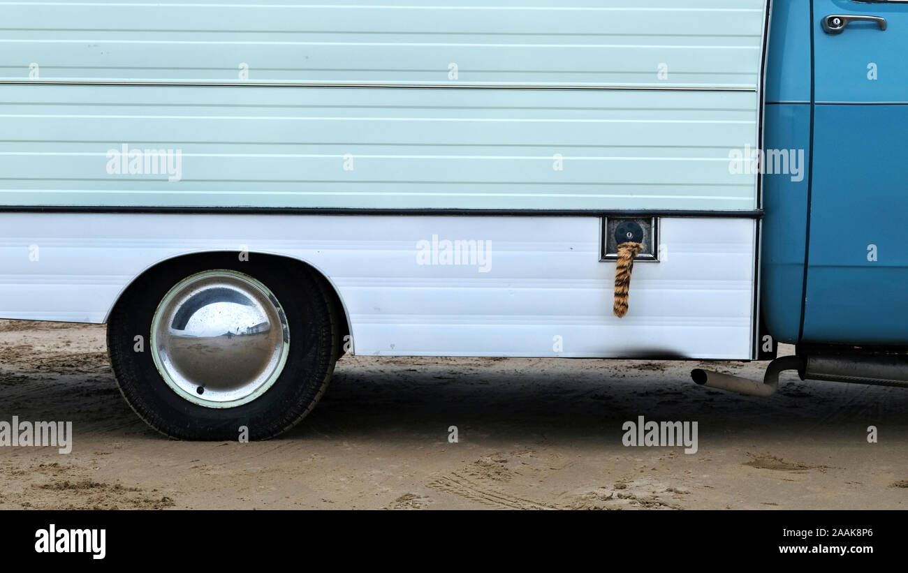 Ein alter Wohnmobil mit einem Pelztierschwanz, der an seinem Benzintank hängt. Diese waren in den 1960er Jahren nach einer Esso-Werbekampagne populär. Stockfoto