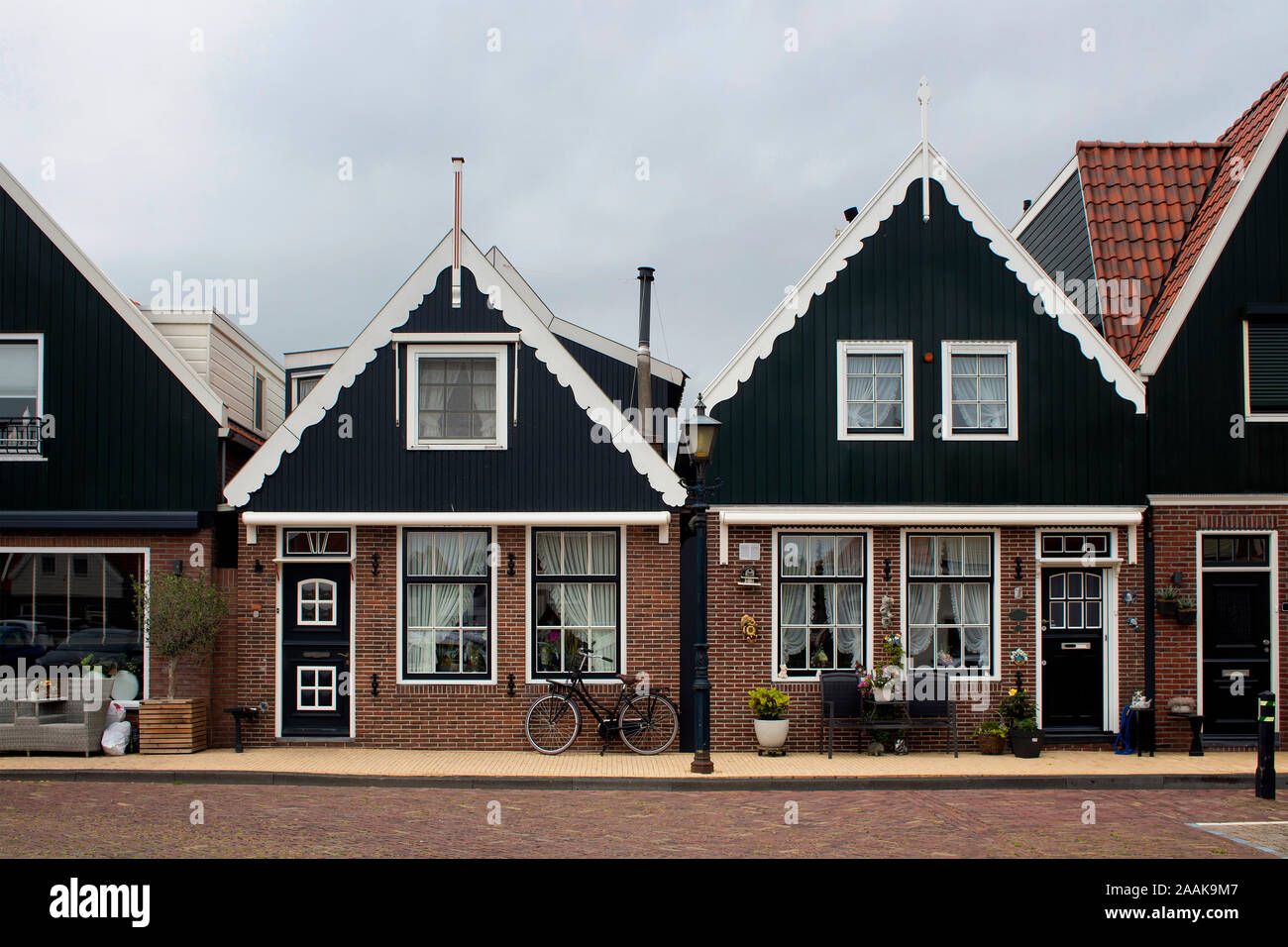 Blick auf historische und traditionelle Häuser, Pflanzen, Fahrrad und Blumen in Volendam. Es ist eine niederländische Stadt, im Nordosten von Amsterdam. Es ist bekannt für seine Col Stockfoto