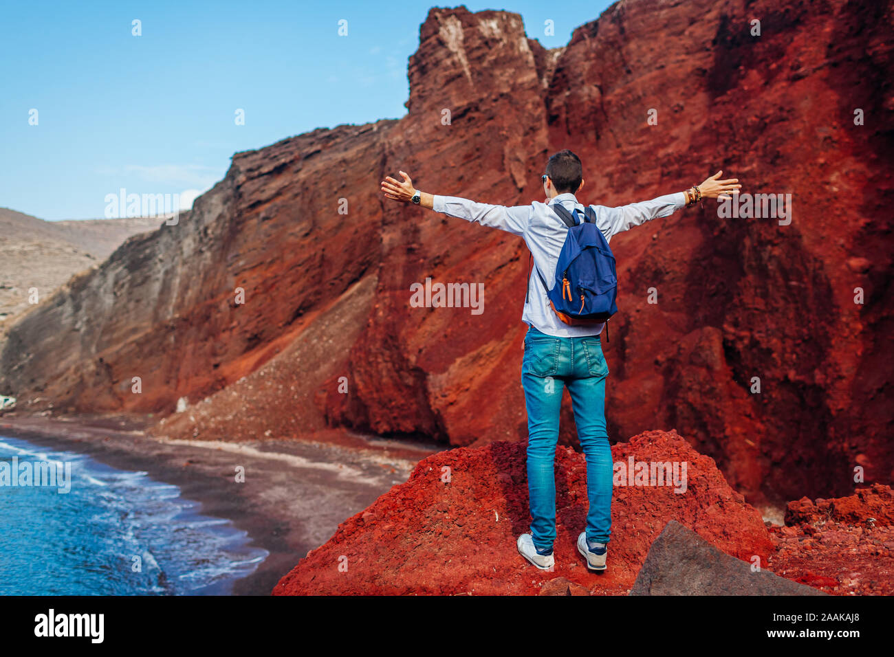 Reisende am Roten Strand Landschaft mit erhobenen Armen Gefühl in Akrotiri, Santorini, Griechenland glücklich. Reisen Stockfoto