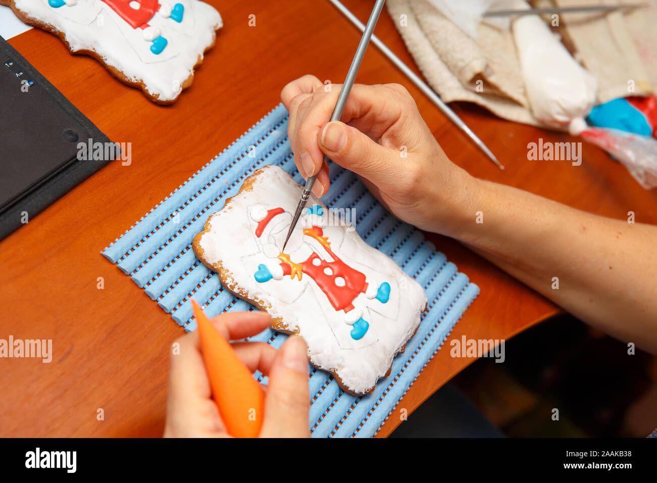Ein junges Mädchen ist in Dekoration Lebkuchen Cookies eingeschaltet. Weihnachten und Neujahr Geschenke und die Herstellung von Lebkuchen Kekse für Weihnachten Stockfoto