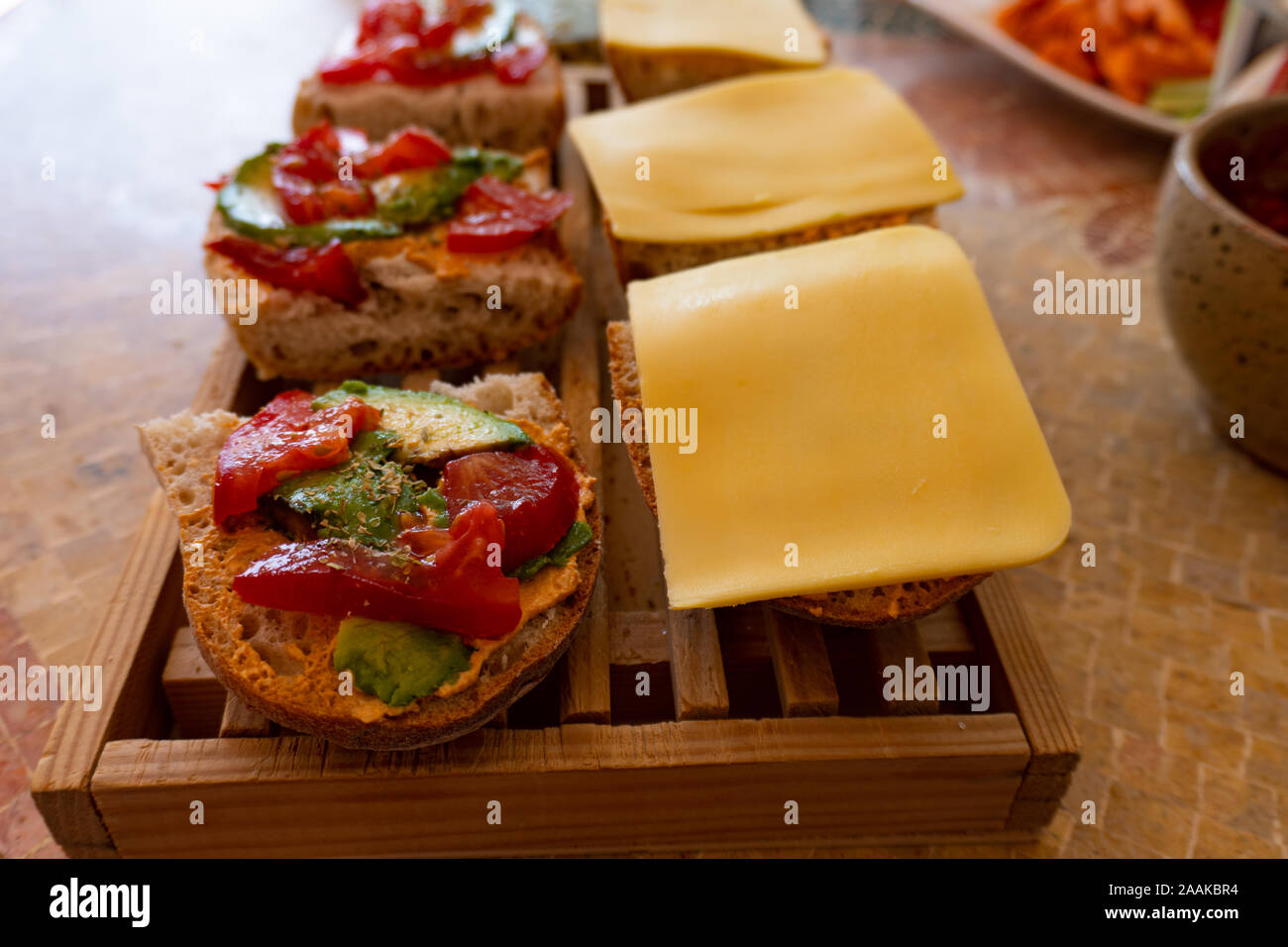 Veganen Sandwiches mit Avocado, Tomaten und veganer Käse auf einem hölzernen Fach Stockfoto