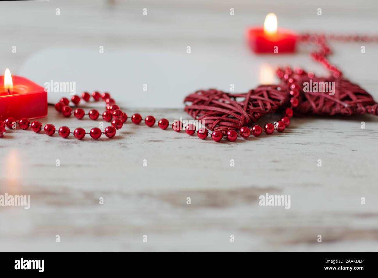 Herz mit roten Perlen Kette und Kerzen auf Holz- Hintergrund. St. Valentines Tag oder Hochzeit Karte Konzept mit kopieren. Stockfoto