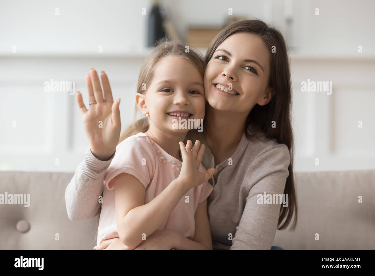 Glückliche Mutter und Tochter Blick in die Kamera winken Stockfoto