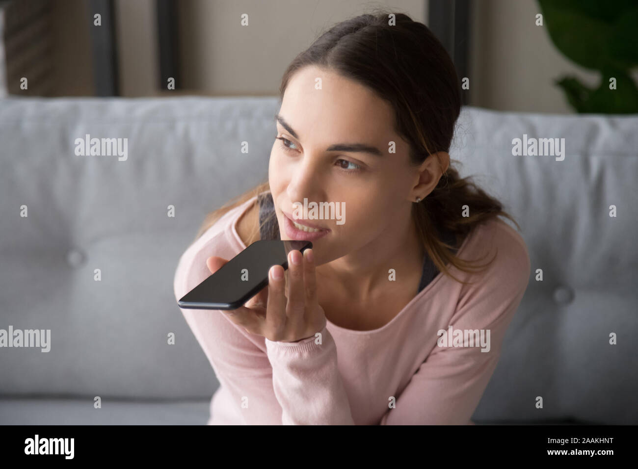 Tausendjährige Frau mit Smartphone Aufzeichnung von Sprachnachrichten Stockfoto