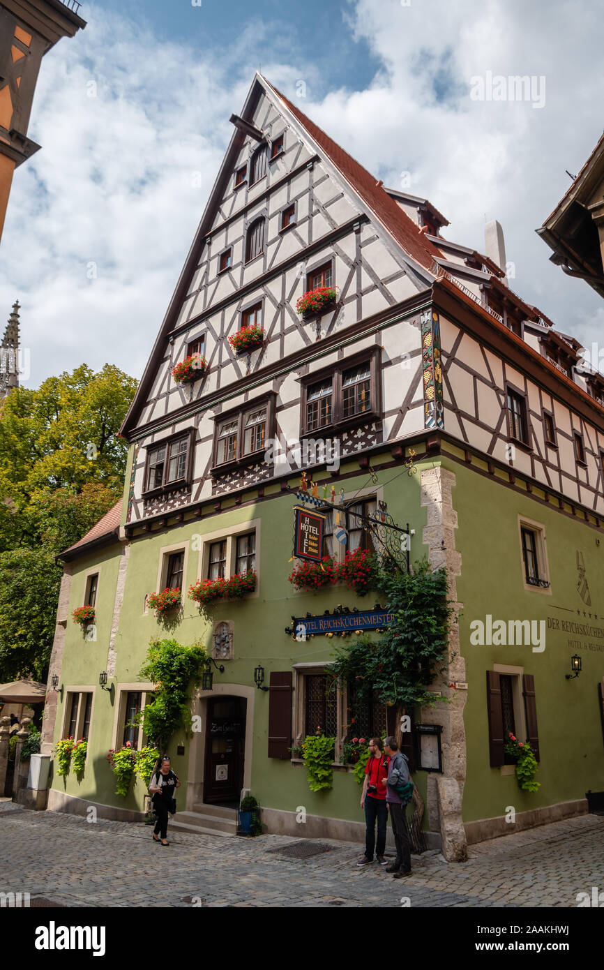 Touristen vor einem der charmanten Hotels, in einem alten Patrizierhaus. Diese mittelalterliche Stadt ist Teil der berühmten Romantischen Straße in Deutschland. Stockfoto