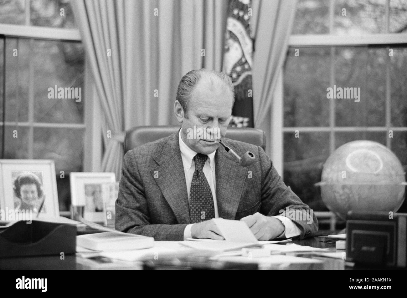 Us-Präsident Gerald Ford arbeitet an seinem Schreibtisch, das Rauchen einer Pfeife, White House, Washington, D.C., USA, Foto: Marion S. Trikosko, 6. Februar 1975 Stockfoto