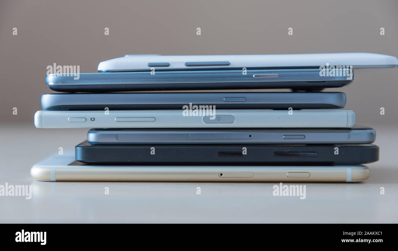 Smartphones Nahaufnahme Bild mit Geräten in Haufen übereinander auf einen weißen Holz- Oberfläche als Ausstellung platziert gestapelt angeordnet Stockfoto