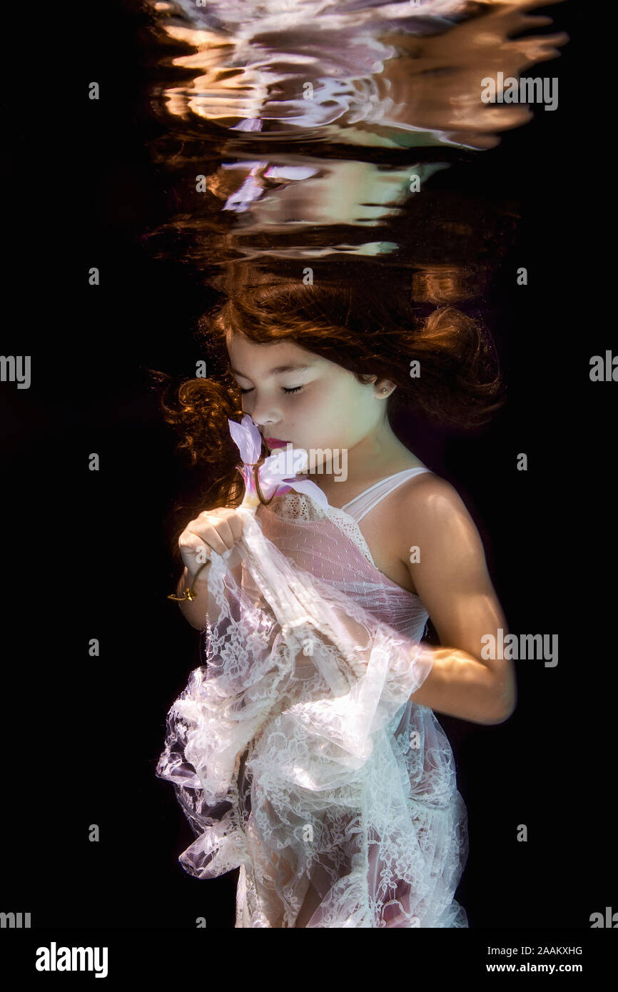 Kleines Mädchen unter Wasser die Augen geschlossen, in einem Garten unter Wasser Stockfoto