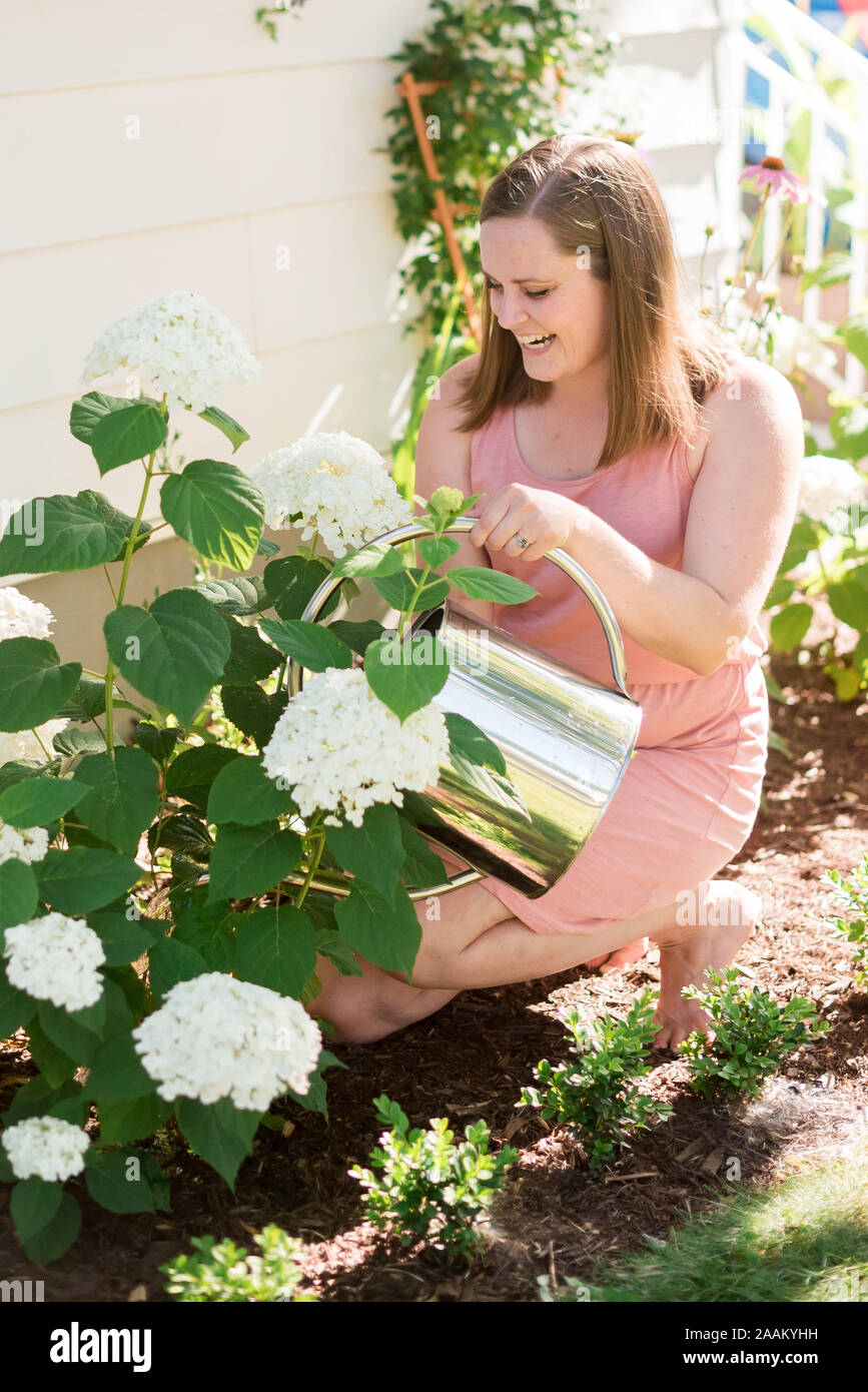 Frau, die Blumen im Garten gießen Stockfoto