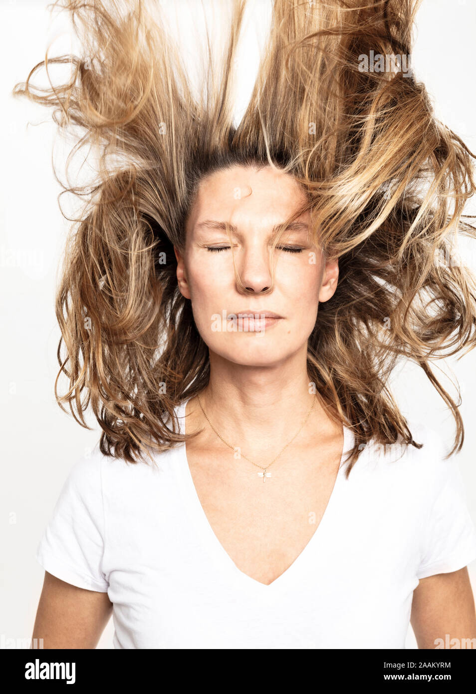 Frau mit fliegenden Haare schließen die Augen, weißer Hintergrund Stockfoto