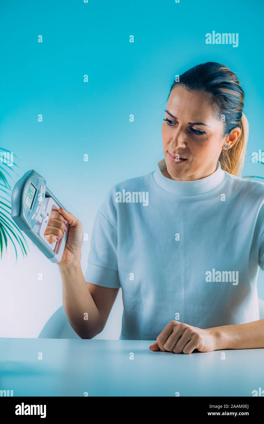 Frau mit digitalen hand grip Dynamometer und Smart Phone. Stockfoto