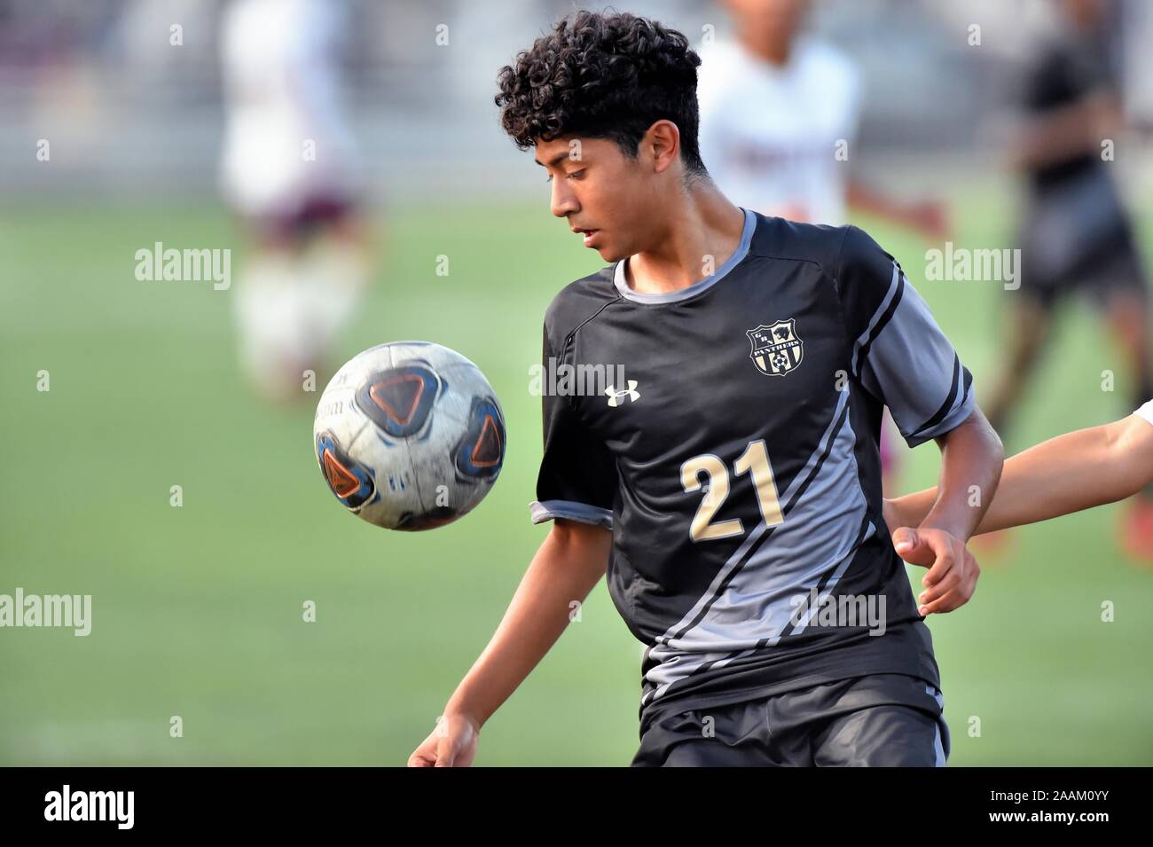 Spieler, die versuchen, einen erhöhten Ball zu kontrollieren, während sie versuchen, einen offensiven Ansturm am Leben zu halten. USA. Stockfoto